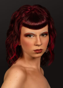 Model mit burgunderrotem, welligem Bob und geradem Micro-Pony – kreative Frisurenkollektion von Hairgott
