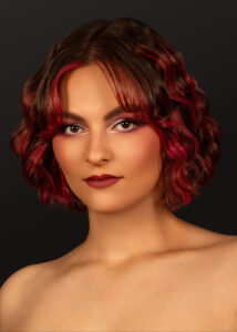 Model mit welligem dunkelbraunem Bob und leuchtend roten Highlights – Hairgott Frisurenkollektion