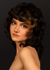 Voluminöse dunkle Locken mit Pony und goldbraunen Highlights – Hairgott Kollektion